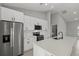 Close up of a modern kitchen with white cabinets, stainless steel appliances, and a quartz countertop island at 166 Bunker Rd, Rotonda West, FL 33947