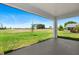 The covered patio offers a view of the community's green space and golf course beyond at 166 Bunker Rd, Rotonda West, FL 33947