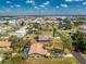 Aerial view of a home with a pool in a residential neighborhood, surrounded by lush trees at 1670 Faust Dr, Englewood, FL 34224