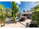 Outdoor patio with a built-in hot tub and screened-in pool area surrounded by lush tropical foliage at 1670 Faust Dr, Englewood, FL 34224