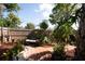 Private backyard featuring a brick patio, wooden bench, and lush landscaping surrounded by a wooden fence at 1670 Faust Dr, Englewood, FL 34224