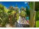 Lush tropical backyard with manicured pathway leading to a pool area, showcasing a private oasis at 1670 Faust Dr, Englewood, FL 34224
