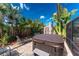 Backyard featuring a hot tub, lounge chair, and lush tropical landscaping at 1670 Faust Dr, Englewood, FL 34224