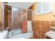 Bathroom featuring earth tone ceramic tile, shower-tub combination, and a window with plantation shutters at 1670 Faust Dr, Englewood, FL 34224