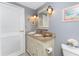 Bathroom featuring tile flooring, a vanity with a decorative mirror, and ample lighting at 1670 Faust Dr, Englewood, FL 34224