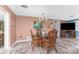 Charming dining room featuring a round glass table, wicker chairs, and a decorative chandelier at 1670 Faust Dr, Englewood, FL 34224