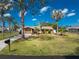 Charming single-story home featuring a well-manicured lawn and tropical landscaping with palm trees on a sunny day at 1670 Faust Dr, Englewood, FL 34224
