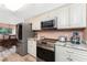 Stylish kitchen featuring white cabinets, granite countertops, and stainless steel appliances for modern convenience at 1670 Faust Dr, Englewood, FL 34224