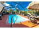 Inviting pool within a screened enclosure, featuring a dining area and lush greenery at 1670 Faust Dr, Englewood, FL 34224