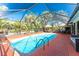 Beautiful pool within a screened enclosure surrounded by lush tropical landscaping at 1670 Faust Dr, Englewood, FL 34224