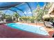 Sparkling pool within a screened enclosure surrounded by tropical landscaping at 1670 Faust Dr, Englewood, FL 34224