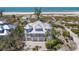 Aerial view of a stately home by the beach, featuring multiple stories, turrets, and lush landscaping at 17 Seawatch Dr, Boca Grande, FL 33921