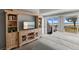 Bright bedroom featuring a custom entertainment center, a plush bed, and a sliding glass door leading to the outdoor deck with an ocean view at 17 Seawatch Dr, Boca Grande, FL 33921