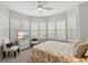 Bright bedroom featuring a ceiling fan, a bay window with white shutters and a TV at 17 Seawatch Dr, Boca Grande, FL 33921
