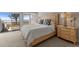 Cozy bedroom featuring a plush bed, a wooden dresser, and a sliding glass door leading to the outdoor deck with an ocean view at 17 Seawatch Dr, Boca Grande, FL 33921