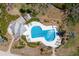 Aerial shot of a sparkling community pool surrounded by lush landscaping and plenty of lounge chairs at 17 Seawatch Dr, Boca Grande, FL 33921