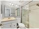 Bright bathroom featuring a shower with glass doors, a large mirror, and a beige vanity at 1701 Beach Rd # 208, Englewood, FL 34223
