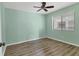 Bright bedroom with wood-look flooring, ceiling fan and a large window at 1701 Beach Rd # 208, Englewood, FL 34223