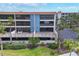 Exterior view of condos featuring patios, red tile roof, and lush green space at 1701 Beach Rd # 208, Englewood, FL 34223