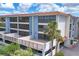 Exterior building view with spacious patios, red tile roof, and lush landscaping at 1701 Beach Rd # 208, Englewood, FL 34223