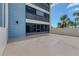 Exterior view showing access to patio, blue facade, and palm trees at 1701 Beach Rd # 208, Englewood, FL 34223