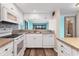 Charming kitchen featuring white cabinetry and mosaic tile backsplash, and open access to the dining area at 1701 Beach Rd # 208, Englewood, FL 34223