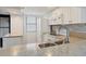Galley-style kitchen with white appliances, tile backsplash, and ample counter space at 1701 Beach Rd # 208, Englewood, FL 34223
