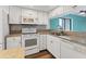 Kitchen with white cabinetry, mosaic tile backsplash, stainless steel sink, and modern appliances at 1701 Beach Rd # 208, Englewood, FL 34223