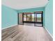 Bright living room with sliding glass doors to screened balcony and new vinyl floors at 1701 Beach Rd # 208, Englewood, FL 34223