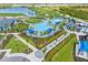 Aerial view of community resort style pool, lake and golf course with lush tropical landscaping at 17645 Boracay Ct # 202, Venice, FL 34293