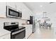 Modern kitchen features stainless steel appliances and sleek white cabinets at 17645 Boracay Ct # 202, Venice, FL 34293