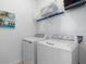 Functional laundry area with a modern washer and dryer, and practical storage shelving at 17645 Boracay Ct # 202, Venice, FL 34293