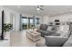Bright and spacious living room with tiled flooring, ceiling fan, and glass sliding door with view at 17645 Boracay Ct # 202, Venice, FL 34293