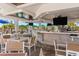 Indoor/outdoor dining area with an elegant bar, ample seating, and sunny views at 17645 Boracay Ct # 202, Venice, FL 34293