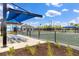 Community tennis courts surrounded by lush landscaping and covered seating areas at 17645 Boracay Ct # 202, Venice, FL 34293