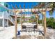 Backyard lounge area features pergola seating, pavers, and natural sand landscape at 180 S Gulf Blvd, Placida, FL 33946