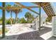 Backyard with brick paver walkway, stairs, and patio with mature landscaping at 180 S Gulf Blvd, Placida, FL 33946