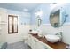 Stylish bathroom with double sinks, decorative wood vanity, and blue-themed décor at 180 S Gulf Blvd, Placida, FL 33946