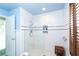 Modern bathroom with white subway tile, glass shower, and dark wood shutters at 180 S Gulf Blvd, Placida, FL 33946