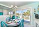 Cozy dining area boasts a round table, colorful chairs, and slider to outdoor balcony at 180 S Gulf Blvd, Placida, FL 33946