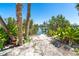 Inviting dock access amidst lush greenery and sandy pathways, offering a serene waterfront experience at 180 S Gulf Blvd, Placida, FL 33946