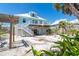 Exterior view of elevated coastal home with beach landscaping, white stairs, and a metal roof at 180 S Gulf Blvd, Placida, FL 33946