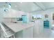Stylish kitchen features retro blue appliances, white cabinets, and a quartz countertop bar at 180 S Gulf Blvd, Placida, FL 33946