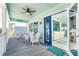 Inviting porch with rocking chairs, ceiling fan, and glass door leading to interior at 180 S Gulf Blvd, Placida, FL 33946