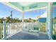 Relaxing porch with swing overlooking lush tropical landscape and neighborhood at 180 S Gulf Blvd, Placida, FL 33946