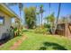 Landscaped backyard with lush green grass, mature tropical plants and a stone walking path at 20 Spaniards Rd, Placida, FL 33946