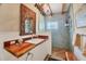Unique bathroom with a wood countertop, ornate mirror, and a glass-enclosed shower at 20 Spaniards Rd, Placida, FL 33946