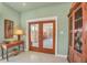 Stylish home entryway featuring French doors leading to the side patio, light green walls, and decorative furniture at 20 Spaniards Rd, Placida, FL 33946