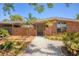 Single-story brick home featuring an enclosed side patio, manicured front yard, and crushed gravel walkway at 20 Spaniards Rd, Placida, FL 33946