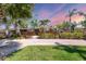 Charming single-story brick home with a lush front yard, rock driveway, and beautiful tropical landscaping at 20 Spaniards Rd, Placida, FL 33946